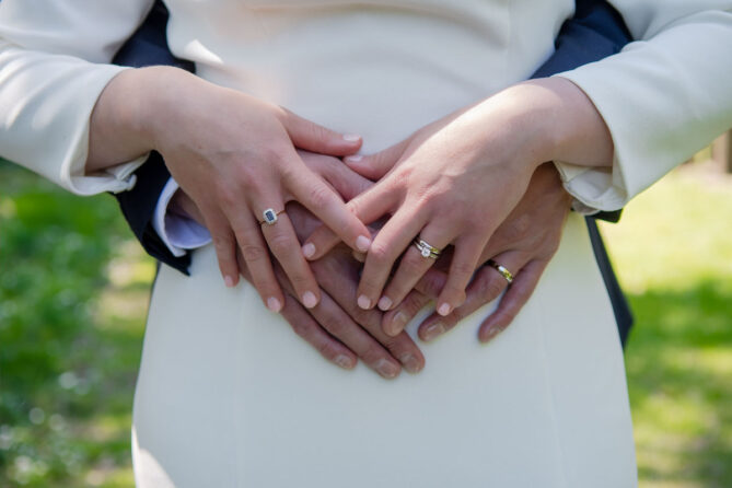Detail photo of bride and groom's hands showing their rings